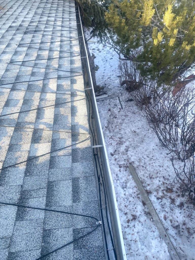 Heat cables installed along a Calgary roof to prevent ice dams and ensure proper drainage. For homes with chronic ice damming issues, heat cables provide a reliable long-term solution by maintaining a steady melt path.