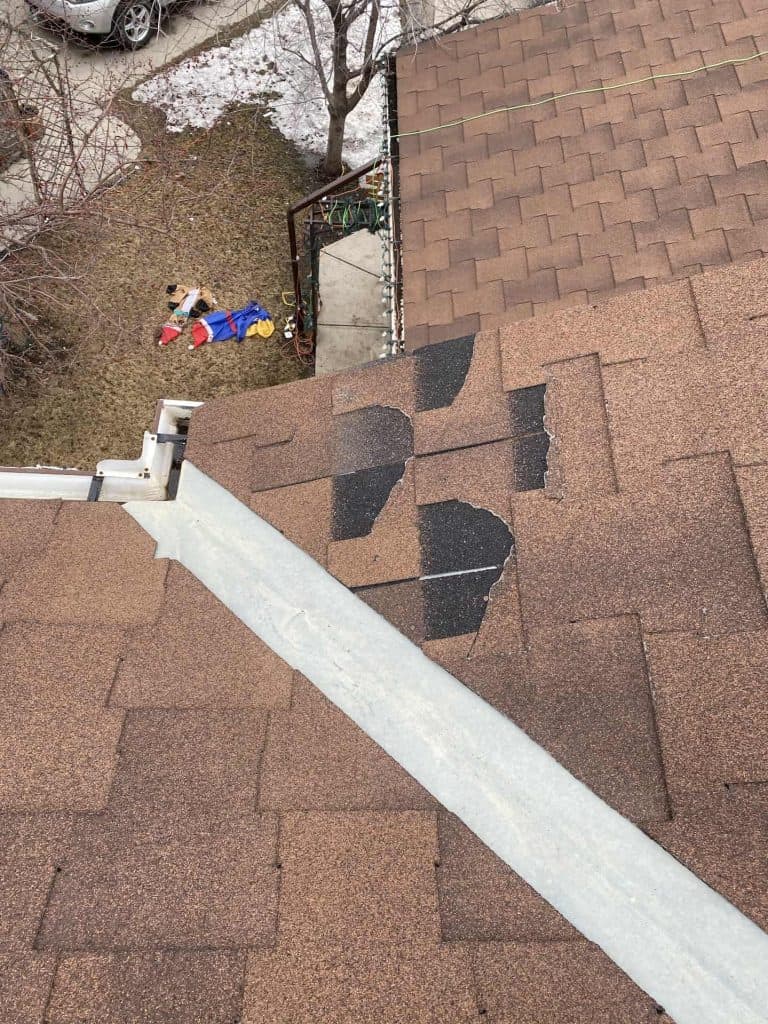 Broken roof shingles on a home in Calgary, Alberta.