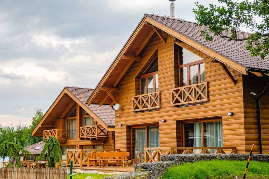 Modern wooden house with big windows in the suburb. Building of houses for the key. Cottage or pension near the forest in countryside.