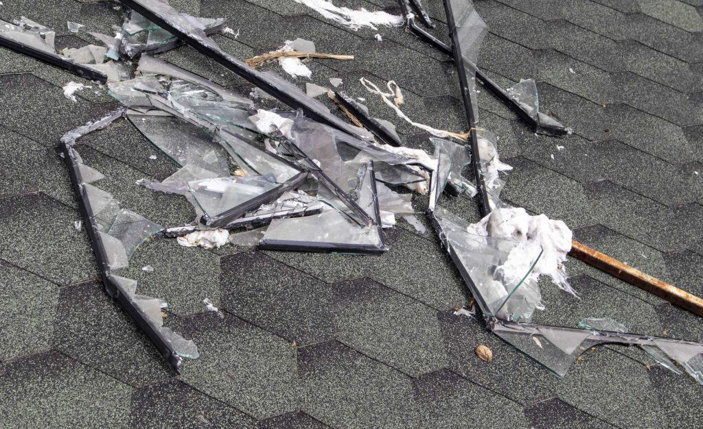 Skylight damaged during a storm with debris over the roof