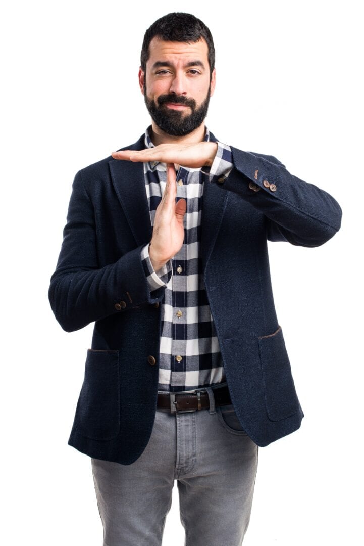 Handsome man making time out gesture, signalling stop the rush when it comes to the first step in not getting scamed.